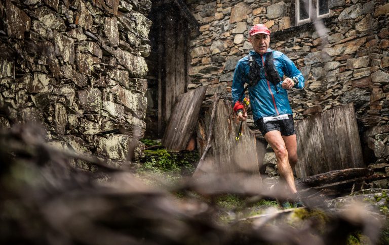 Atleta do Louzantrail a correr junto a construções de xisto